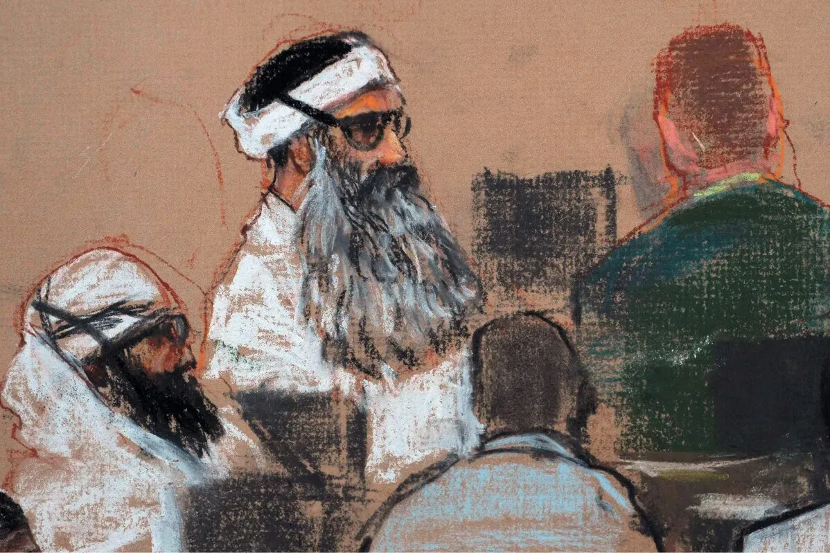 خالد شيخ محمد، المتهم الرئيسي في هجمات 11 سبتمبر، يتحدث في قاعة المحكمة، محاطًا بمحاميه ومراقبين.