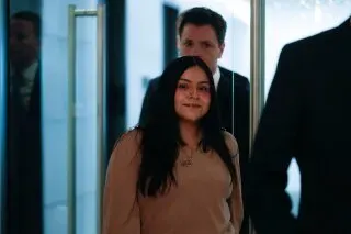 امرأة شابة تدخل مبنى مع محامٍ، تعبيرها هادئ، في سياق قضية تتعلق بإطلاق نار من قبل عميل فيدرالي في شيكاغو.