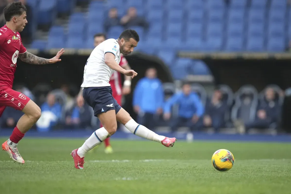 لاعب كرة قدم يسدد الكرة في مباراة، مع وجود لاعب آخر يقترب منه، في سياق منافسة الدوري الإيطالي.