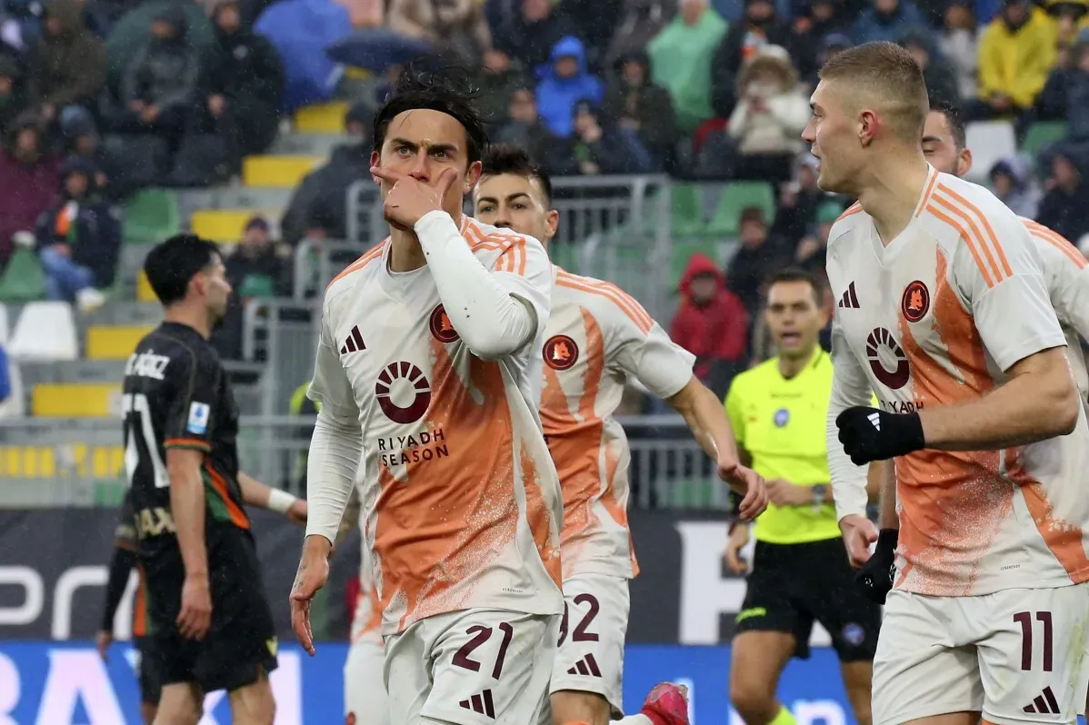 لاعبو فريق روما يحتفلون بعد تسجيل هدف في مباراة ضد فينيسيا، مع التركيز على اللاعب باولو ديبالا.