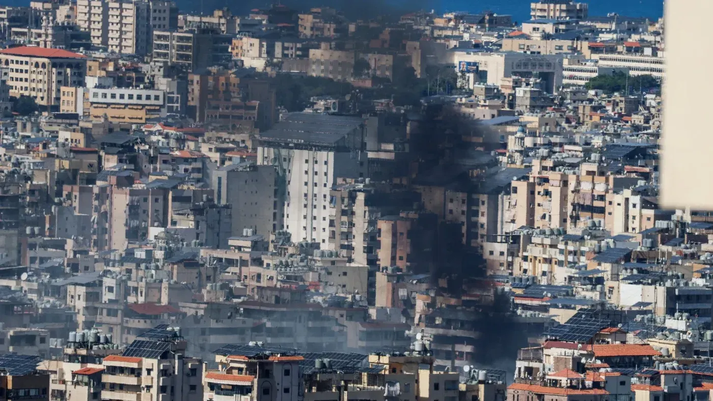 دخان يتصاعد من مباني الضاحية الجنوبية لبيروت بعد غارات إسرائيلية، مع تضرر مناطق سكنية مزدحمة.