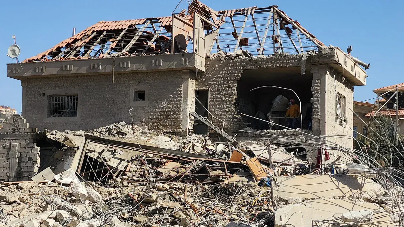 مبنى مدمر في شرق لبنان بعد الغارات الإسرائيلية، يظهر آثار الدمار والخراب، مع وجود أشخاص في الموقع للبحث والإنقاذ.