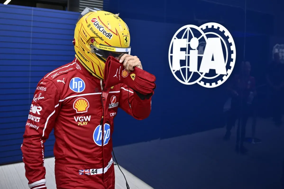 لويس هاميلتون يرتدي خوذته وبدلة سباقه الحمراء، يظهر وهو يغادر منطقة الصيانة بعد تأهله في المركز 12 في سباق جائزة المجر الكبرى.