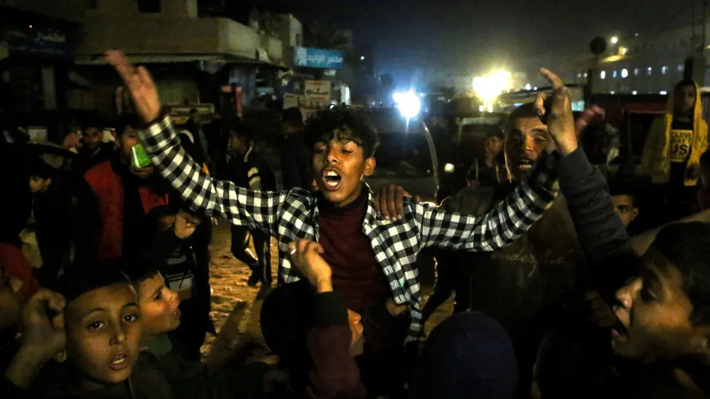 احتفال حماسي في غزة بعد إعلان وقف إطلاق النار، حيث يعبّر النازحون عن مشاعر الأمل والخوف مع تواجد أطفال وشباب في الشوارع.