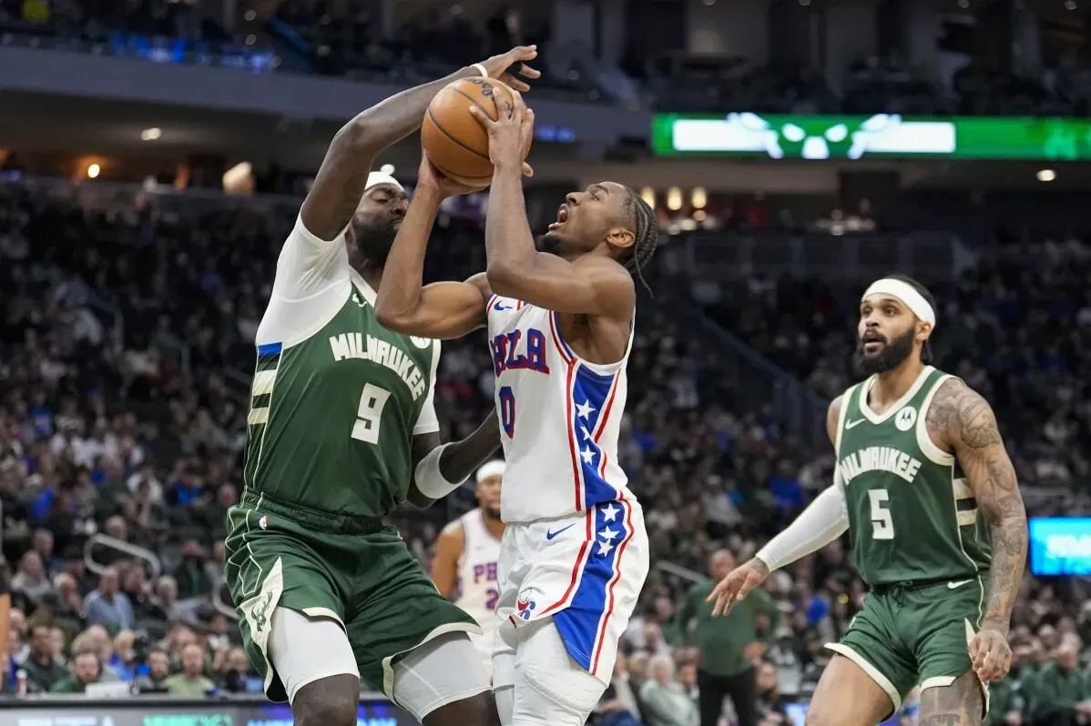 لاعبو ميلووكي باكس وفيلادلفيا 76ers يتنافسون على الكرة في مباراة حماسية، حيث يظهر لاعب باكس رقم 9 في مواجهة لاعب 76ers رقم 0.