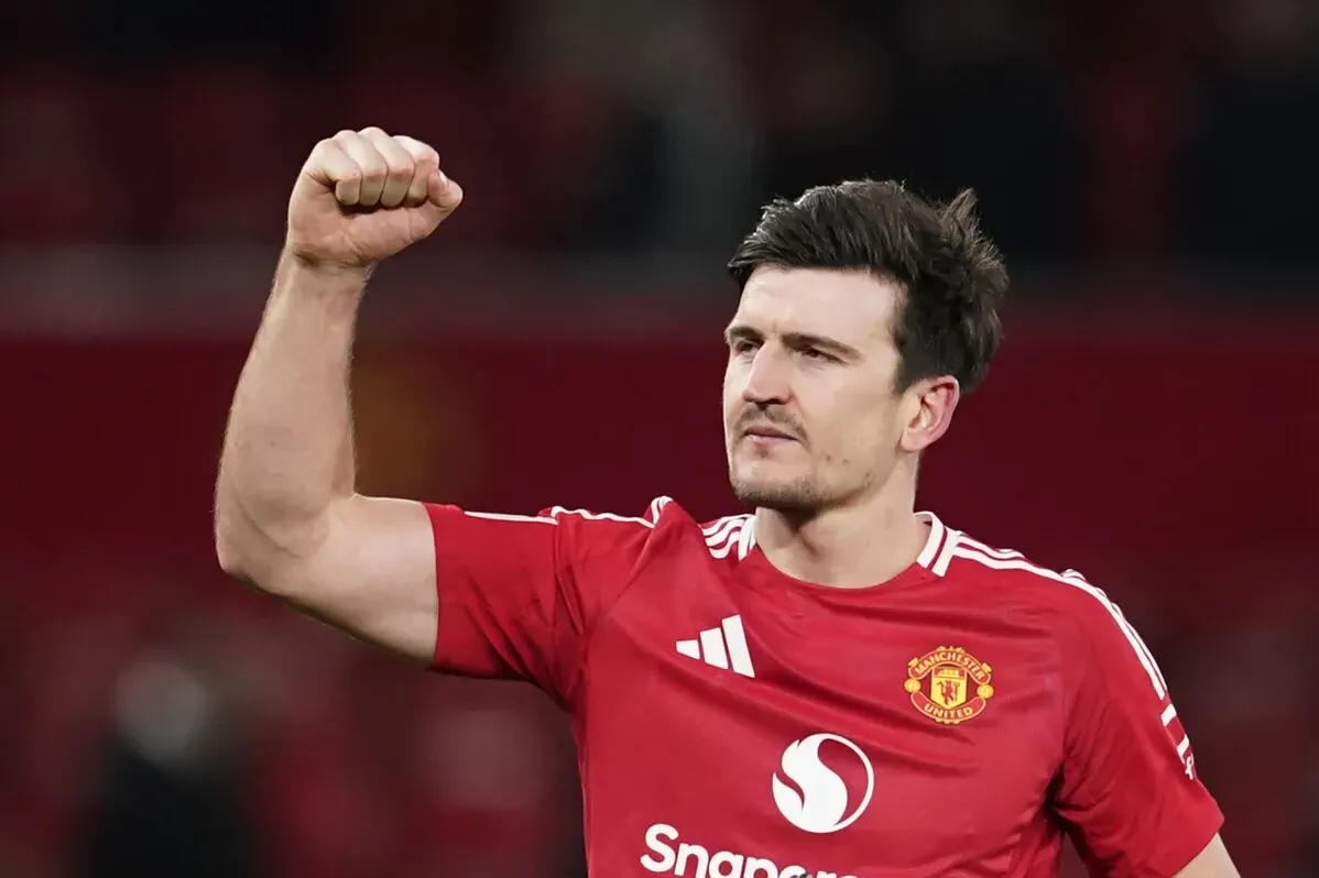لاعب كرة القدم في مانشستر يونايتد، يرتدي قميصًا أحمر، يرفع قبضته في علامة انتصار بعد مباراة.