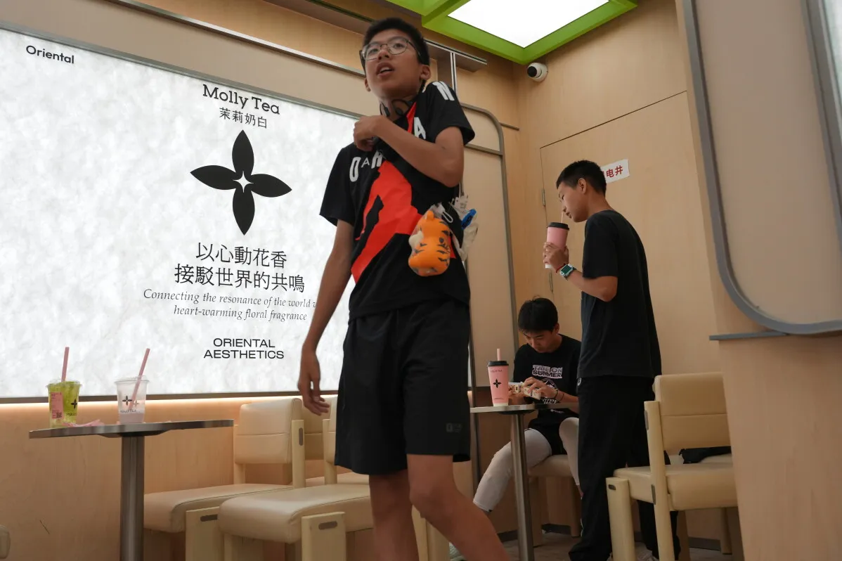 شباب صينيون داخل متجر Molly Tea لشاي الياسمين مع شعار الزهرة الرباعية البتلات المثيرة للجدل المرتبط بقضية حقوق العلامة التجارية مع Louis Vuitton.