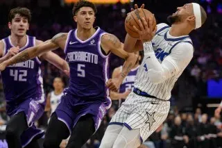 باولو بانشيرو يسجل نقطة تحت ضغط من لاعبي ساكرامنتو خلال مباراة أورلاندو ماجيك وكينجز، حيث حقق ماجيك فوزًا كبيرًا.