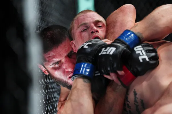 إسلام ماخاشيف يسيطر على منافسه إيان ماتشادو جاري داخل قفص UFC في مباراة دفاع عن لقب وزن 170 رطلاً ضمن UFC 330.