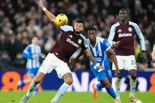 لاعبو أستون فيلا يتنافسون مع لاعبي برايتون في مباراة مثيرة، حيث يظهر لاعب فيلا وهو يسقط بينما يحاول الآخرون السيطرة على الكرة.