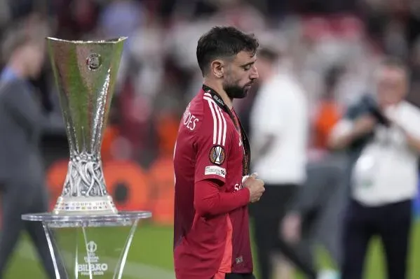 برونو فرنانديز، قائد مانشستر يونايتد، يظهر حزينًا بعد خسارة نهائي الدوري الأوروبي، مع الكأس في الخلفية.
