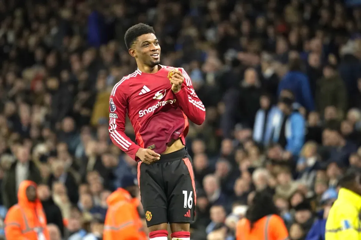 عماد ديالو، لاعب مانشستر يونايتد، يحتفل بتسجيل هدف مهم أثناء مباراة، مع خلفية جماهيرية تعبر عن الحماس.