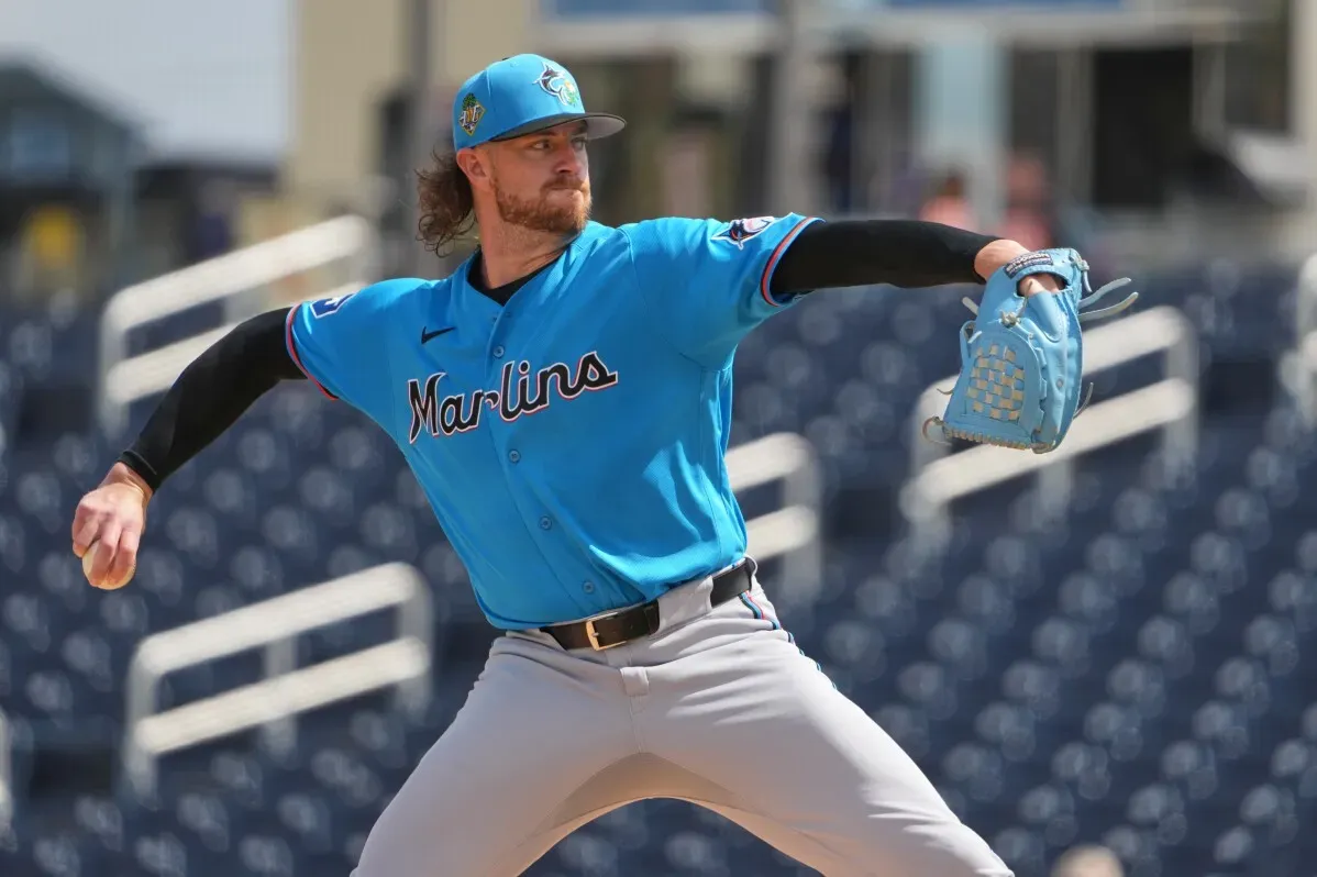 لاعب البيسبول جانسون جانك في زي فريق مارلينز، يستعد لرمي الكرة خلال التدريب، مع خلفية مدرجات فارغة.