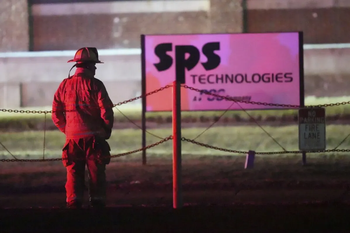 رجال الإطفاء يقفون أمام علامة شركة SPS Technologies بعد اندلاع حريق كبير في منشأتها في جينكينتاون، بنسلفانيا.