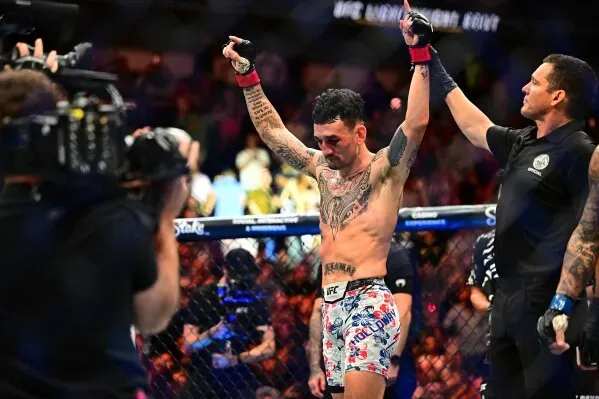 ماكس هولواي يحتفل بفوزه ببطولة UFC BMFC بعد انتصاره على داستن بورييه في نزال مثير، وسط تشجيع حماسي من الجمهور.