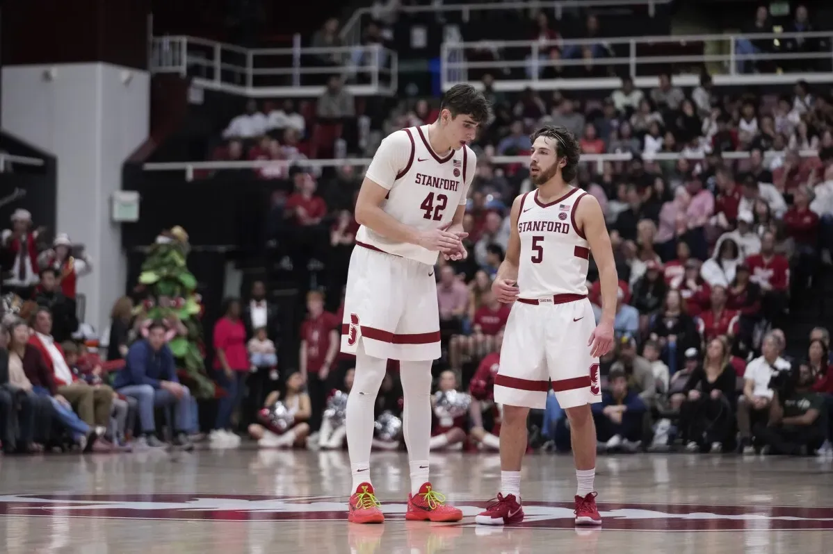 ماكسيم رينو، لاعب كرة سلة في جامعة ستانفورد، يتحدث مع زميله أثناء مباراة في ملعب مابلز بافيليون، وسط جمهور متحمس.