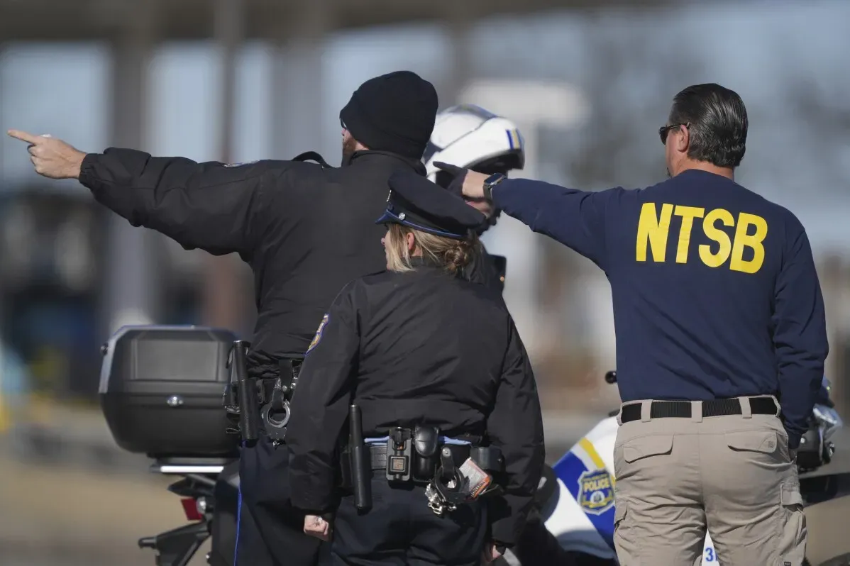 رجال الشرطة ومسؤولو NTSB يتحدثون أثناء توجيه حركة المرور بالقرب من موقع تحطم طائرة في فيلادلفيا، حيث وقع الحادث المأساوي.