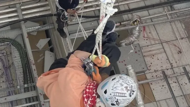 ناشطون يتسلقون السقف باستخدام الحبال خلال اقتحام مصنع لشركة Elbit Systems في ليستر، احتجاجًا على تواطؤ الحكومة في الإبادة الجماعية.