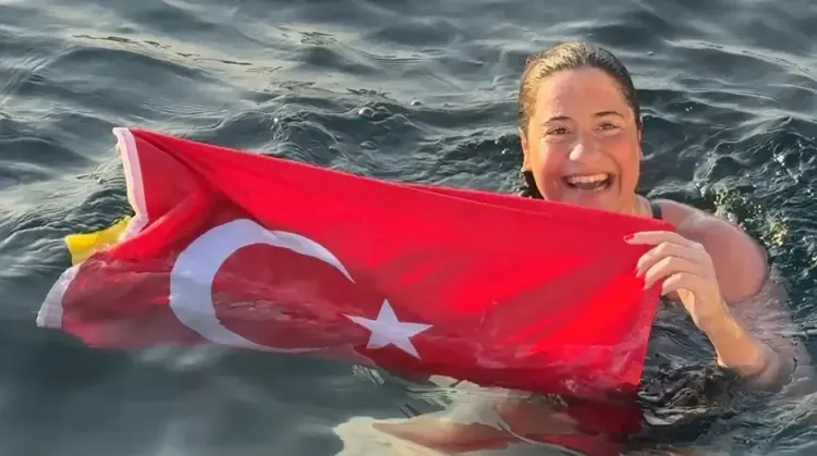 السباحة التركية Aysu Türkoğlu ترفع العلم التركي بفخر بعد إتمام عبور مضيق Tsugaru الياباني ضمن سلسلة Ocean's Seven للسباحة في المياه المفتوحة.