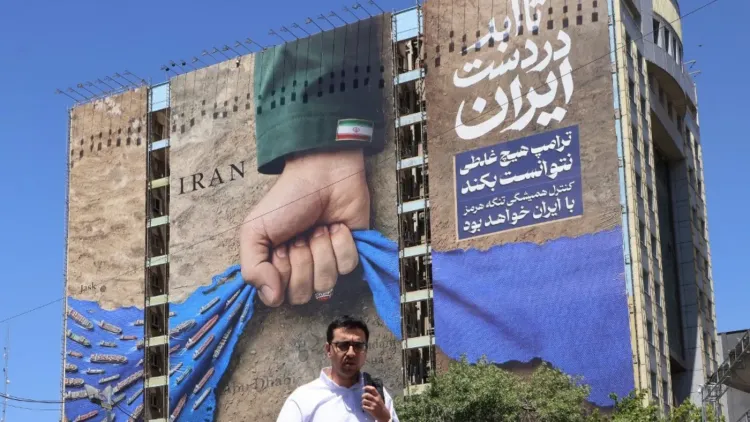 لافتة ضخمة في طهران تظهر يدًا تمسك بخريطة إيران، محاطة بصواريخ، مع نص يعبر عن القوة الوطنية الإيرانية.