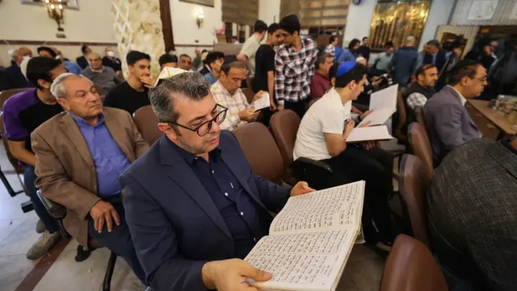 اجتماع لليهود الإيرانيين في طهران، حيث يقرأ المشاركون نصوصًا دينية في أجواء تعكس التوترات السياسية والاجتماعية الراهنة.