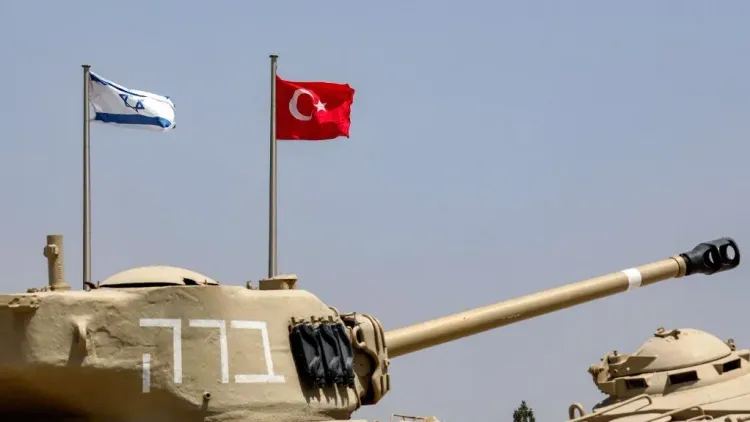 علم تركيا وعلم إسرائيل يرفرفان فوق دبابة في سياق التوترات العسكرية بين البلدين حول قاعدة أبو الظهور في سوريا.