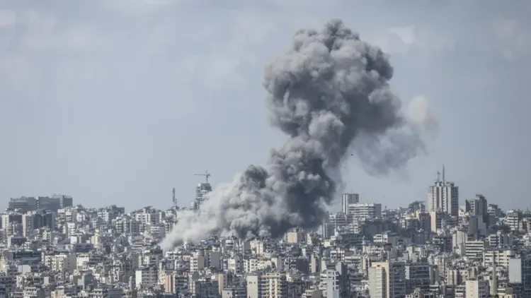 تصاعد أعمدة من الدخان فوق مباني بيروت بعد غارات جوية إسرائيلية، مما يعكس حالة الذعر والدمار في المدينة.