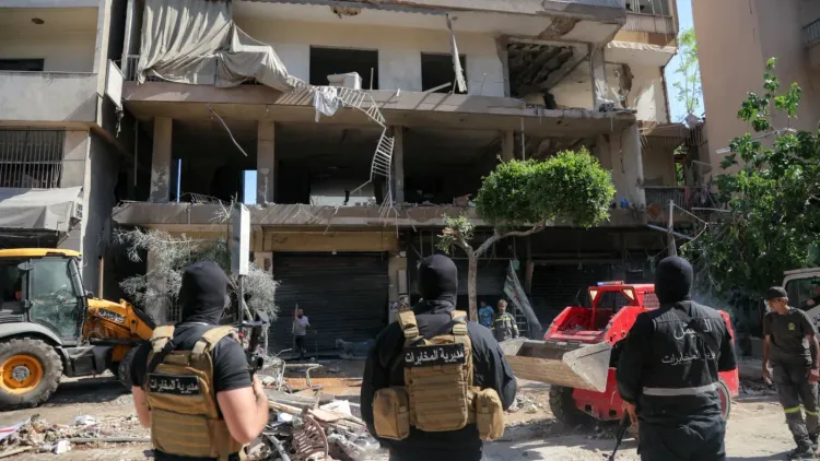 موقع قصف إسرائيلي في الضاحية الجنوبية لبيروت، يظهر مبنىً سكنياً متضرراً وعناصر أمنية في الموقع، بعد الهجوم الذي أودى بحياة ثلاثة أشخاص.