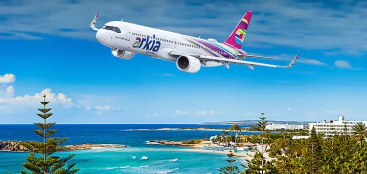 طائرة تابعة لشركة أركيا تحلق فوق البحر، مع مشهد لشاطئ ومنتجعات، في سياق نقل عمليات الشركة إلى الأردن ومصر.