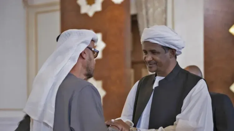 مسؤولان إماراتيان يتصافحان خلال لقاء رسمي يعكس دور الإمارات في دعم قوات الدعم السريع وسط اتهامات بارتكاب فظائع في دارفور.