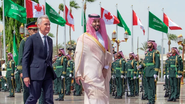 ولي العهد السعودي ورئيس الوزراء الكندي في استقبال رسمي بالرياض وسط أعلام السعودية وكندا، تعبيرًا عن تعزيز التعاون الاقتصادي والتجاري.