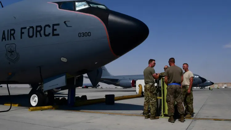 مجموعة من الجنود الأمريكيين يتجمعون بالقرب من طائرة KC-135 للتزود بالوقود في قاعدة عسكرية، وسط توترات متزايدة في العراق.