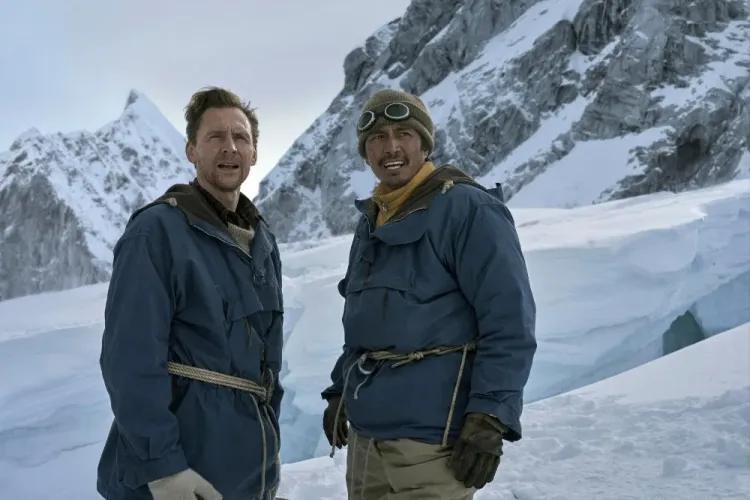 ممثلا فيلم "Tenzing" يرتديان ملابس تسلق في جبال الهيمالايا المغطاة بالثلوج أثناء محاولة صعود إيفرست عام 1953.