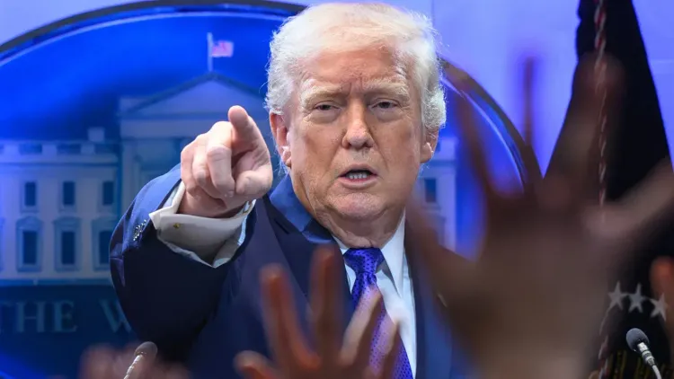 الرئيس الأمريكي دونالد ترامب يشير بيده أثناء مؤتمر صحفي، مع خلفية توضح شعار البيت الأبيض، وسط أجواء من التوترات السياسية حول إيران.