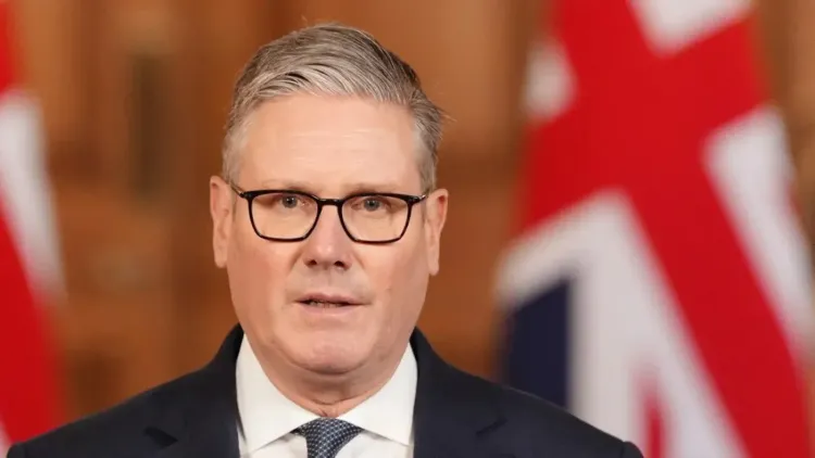كير ستارمر، رئيس الوزراء البريطاني، يتحدث في مؤتمر صحفي حول العمليات الدفاعية في الشرق الأوسط، مع العلم البريطاني خلفه.