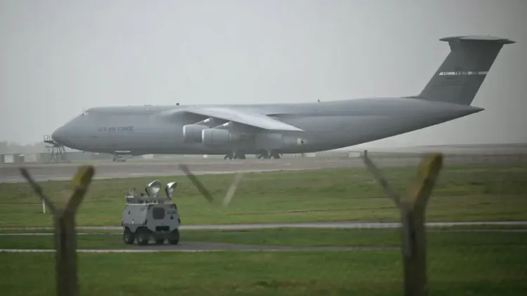 هبوط طائرة شحن C-5 Galaxy التابعة لسلاح الجو الأمريكي في قاعدة فيرفورد، مع وجود مركبة عسكرية على المدرج.
