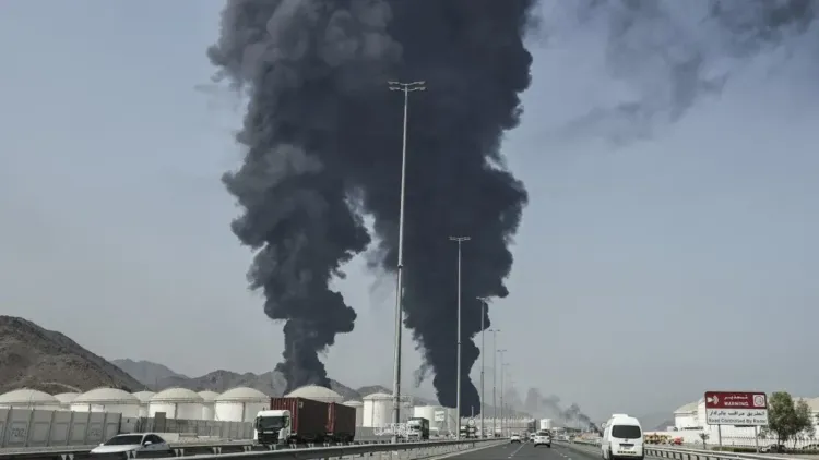 دخان أسود كثيف يتصاعد من منشأة نفطية في الشرق الأوسط، مما يعكس تصاعد التوترات والأزمات الإقليمية.