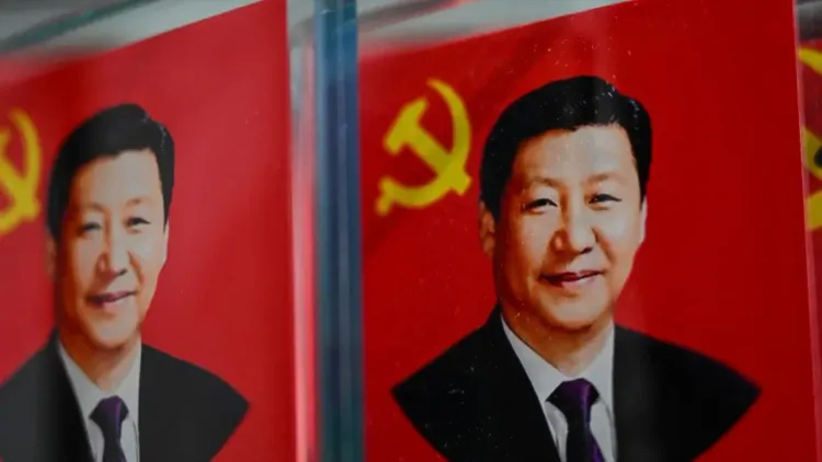 صورة لشي جين بينغ، الرئيس الصيني، أمام خلفية حمراء تحمل شعار الحزب الشيوعي، تعكس السياسة الخارجية الصينية ومبدأ عدم التدخل.