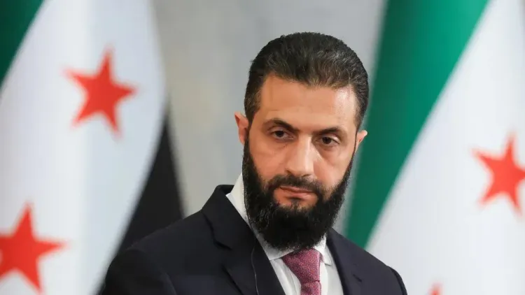 وزير الخارجية السوري أسعد الشيباني في مؤتمر صحفي أمام أعلام الثورة السورية، مع التركيز على الدور السوري في مواجهة حزب الله اللبناني.