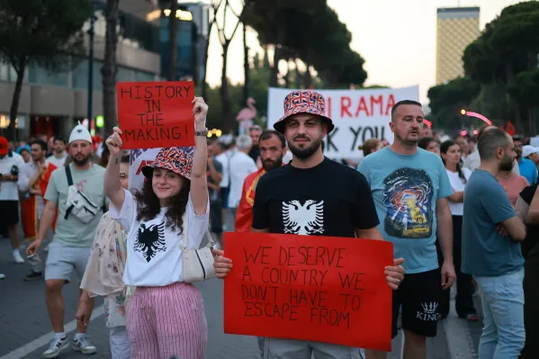 محتجون في تيرانا يحملون لافتات تعبر عن مطالبهم السياسية، وسط أجواء حماسية تعكس "ثورة الفلامنغو" ضد مشروع تطوير ساحلي.