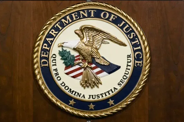 شعار وزارة العدل الأمريكية، يظهر النسر الأمريكي محاطًا بشريط يحمل عبارة "Qui Pro Domina Justitia Sequitur"، رمزية العدالة.