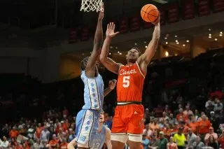 لاعب من فريق ميامي يسجل نقطة خلال مباراة كرة السلة ضد نورث كارولينا، مع تواجد حشد من المشجعين في الخلفية.