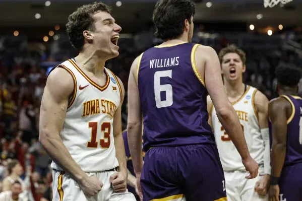 لاعب من فريق ولاية أيوا يحتفل بفوز فريقه في بطولة NCAA، مع التركيز على حماس الفريق بعد تسجيله نقاطًا مهمة.