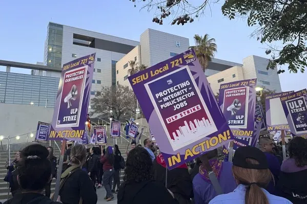 عمال من نقابة SEIU Local 721 يتظاهرون في لوس أنجلوس، حاملين لافتات تطالب بحقوقهم وتأكيد أهمية وظائفهم في القطاع العام.