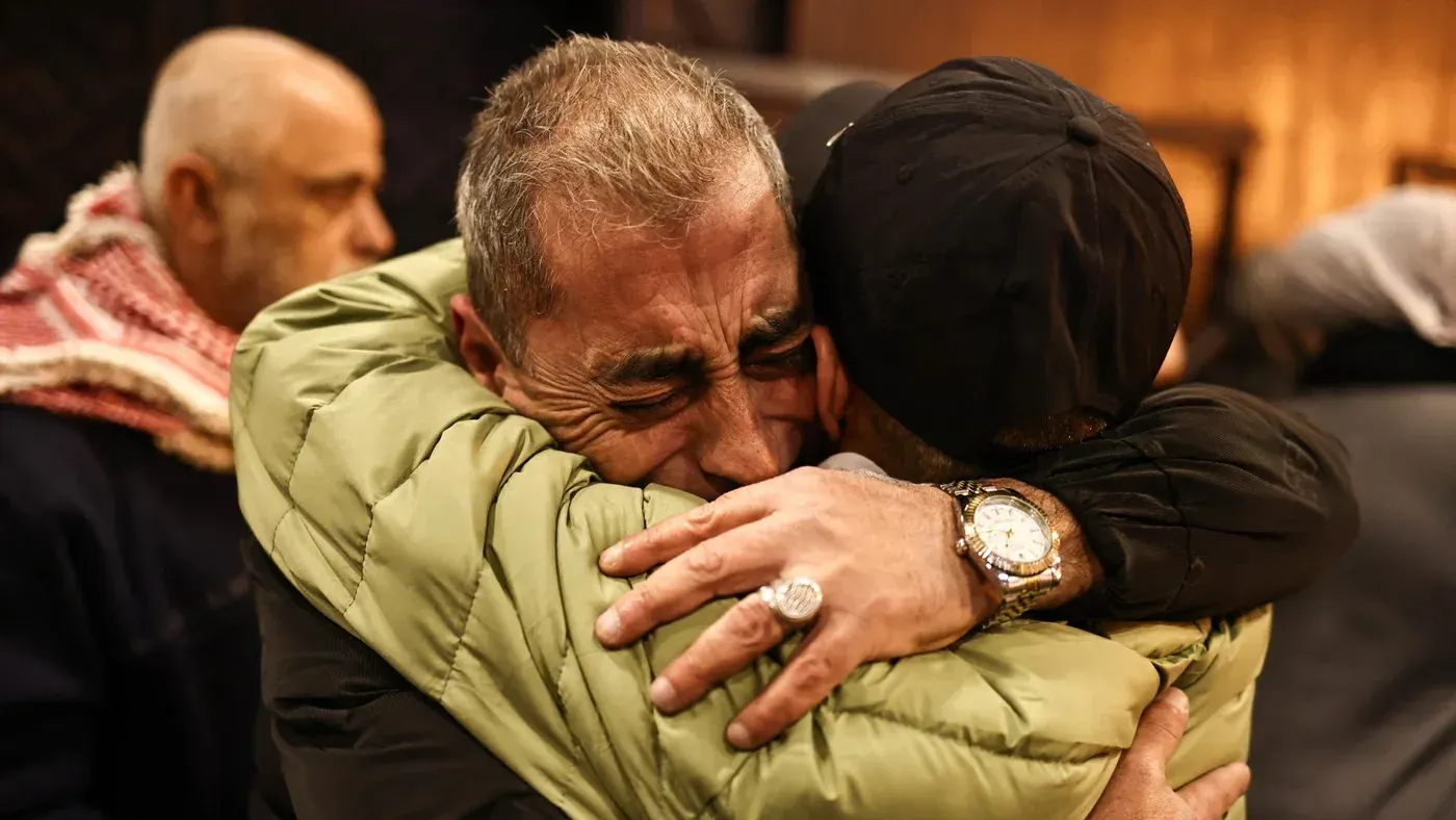 عناق مؤثر بين فلسطينيين بعد إطلاق سراح أكثر من 600 معتقل من السجون الإسرائيلية، مع تعبيرات عن الفرح والقلق من وضع الأسرى المتبقيين.