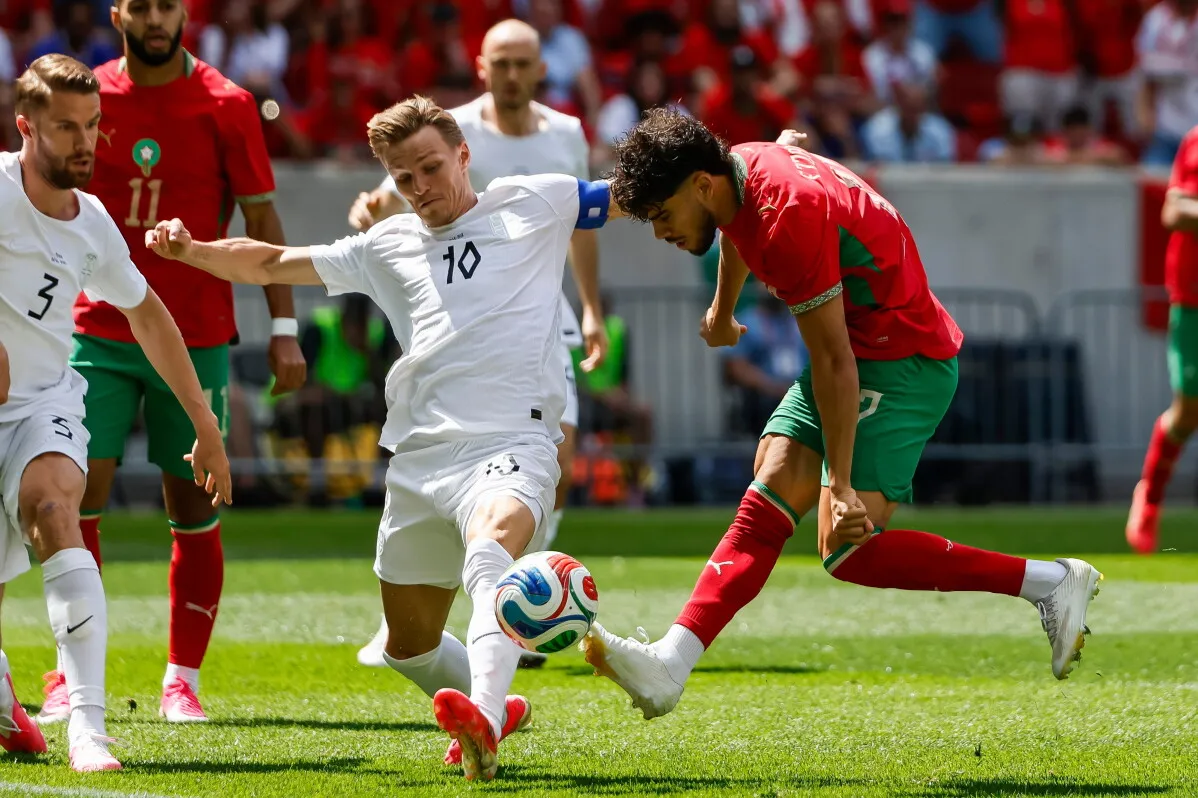 مواجهة بين لاعبين من المنتخب المغربي والخصم، مع التركيز على التحركات التكتيكية قبل مباراة كأس العالم ضد البرازيل.