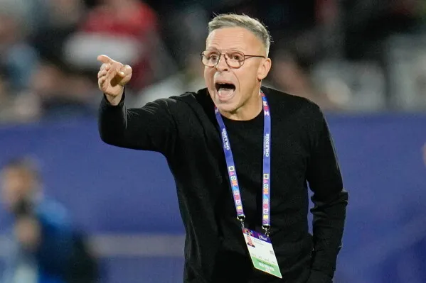 المدرب محمد وهبي يتحدث بحماس أثناء مباراة، مع التركيز على التحديات التي تواجه المنتخب المغربي قبل مواجهة البرازيل.