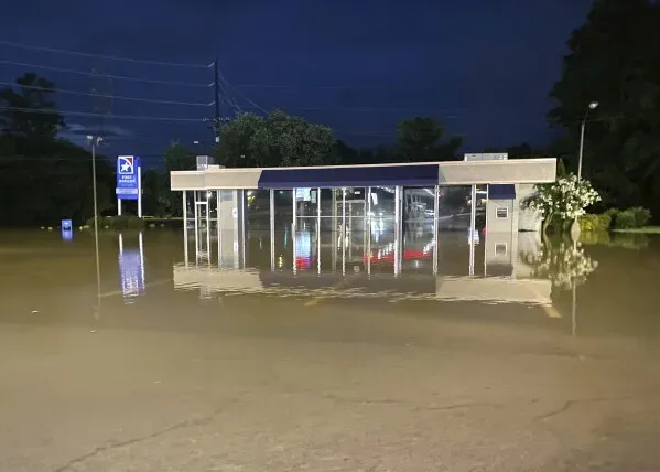 محطة مغلقة مغمورة بالمياه أثناء الفيضانات في تينيسي، مع ارتفاع مستوى المياه حول المبنى، مما يعكس تأثير الأمطار الغزيرة.