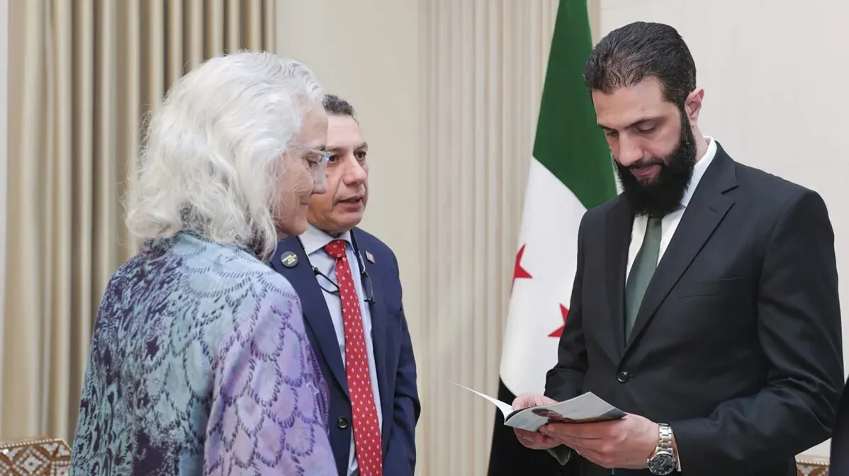 والدة الصحفي الأمريكي أوستن تايس أثناء اجتماع مع مسؤول سوري، تعبيراً عن أملها في العثور على ابنها المفقود منذ 2012.