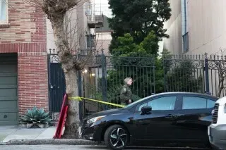 رجل شرطة يقف بالقرب من سياج في حي باسيفيك هايتس بسان فرانسيسكو، حيث تم رصد أسد جبلي صغير يتجول في المنطقة.